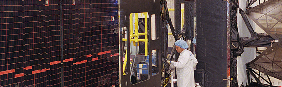 Worker in front of satellite panel